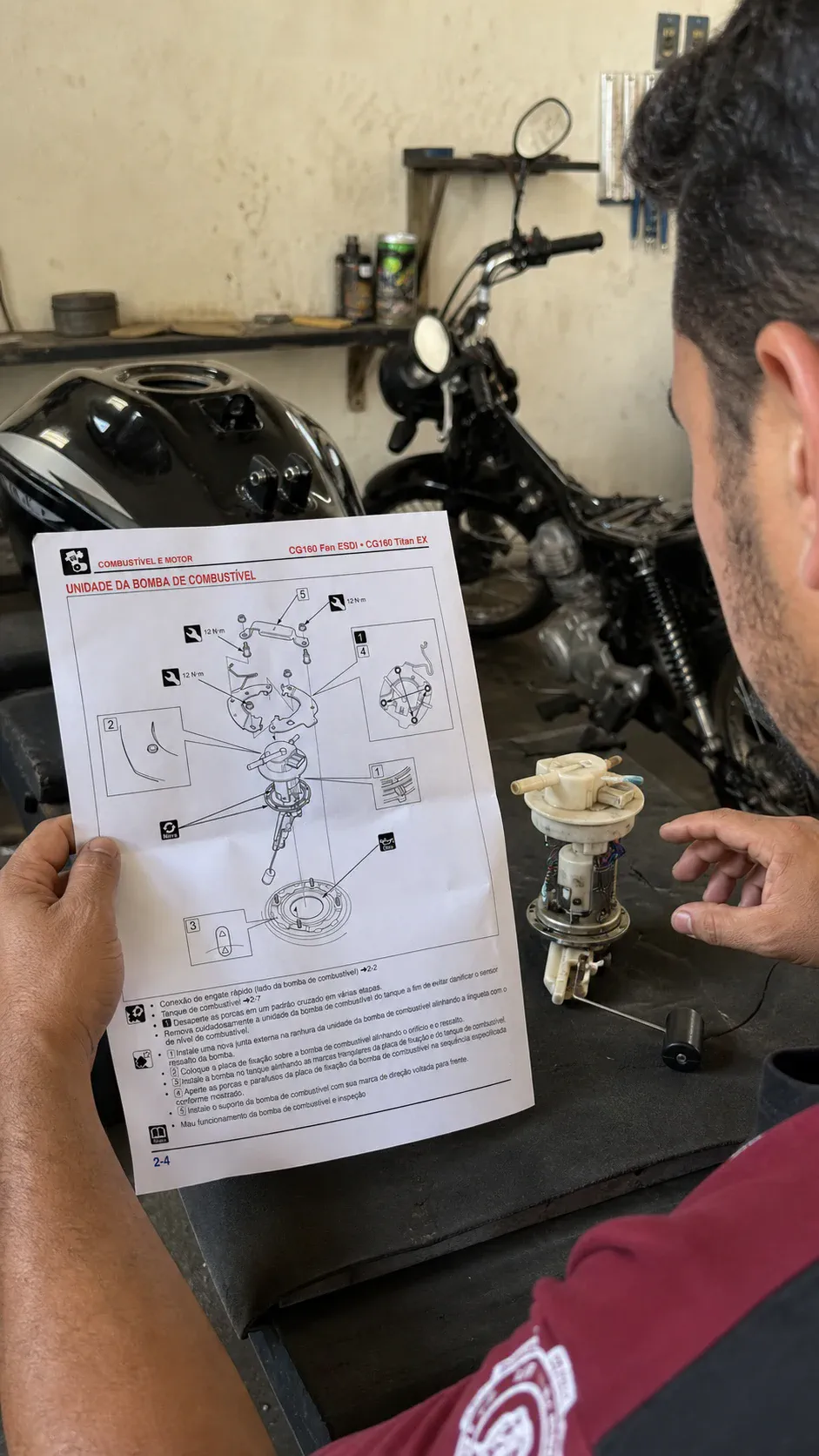 Mecânico consultando diagrama da bomba de combustível na oficina